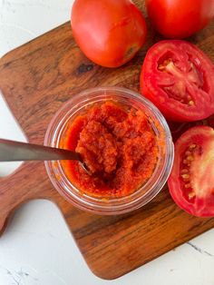 tomatoes and sauce on a cutting board with a knife