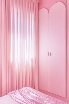 a bedroom with pink walls and curtains