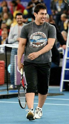 a man walking across a tennis court holding a racquet