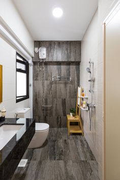 a modern bathroom with black and white tile on the walls, wood flooring, and a walk in shower