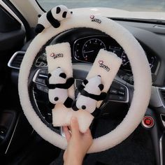 the steering wheel cover has panda bears on it and is white with black trims