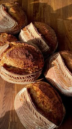 several loaves of bread sitting on top of a wooden table