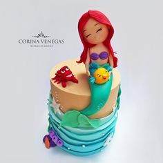 there is a little mermaid on top of the cake