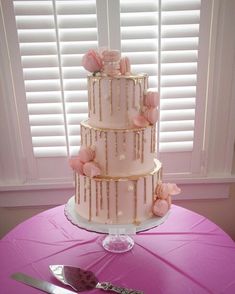 a three tiered cake sitting on top of a table next to a knife and fork