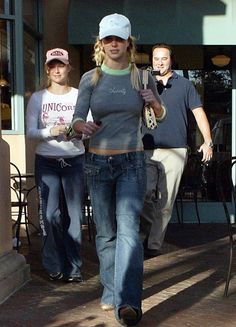 a woman walking down the street with two other people