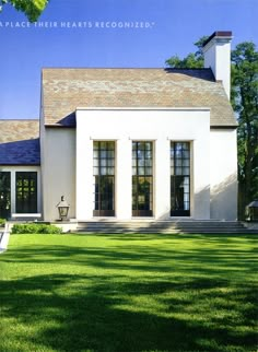 a large white house sitting on top of a lush green field