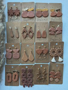 twelve pairs of earrings are displayed on brown cards