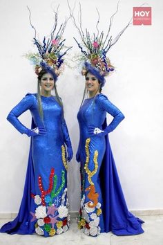 two women in blue dresses standing next to each other