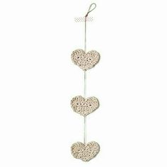 three hearts hanging from a hook on a white wall