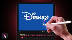 a person writing on a laptop screen with the disney logo in front of them and an apple pencil next to it