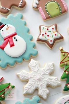 decorated christmas cookies are displayed on a table