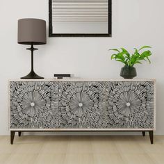 a black and white patterned cabinet next to a lamp