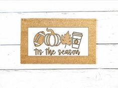 a door mat that says the season with autumn decorations on it and an orange pumpkin