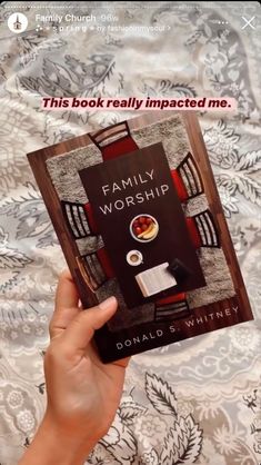 a person holding up a book in their hand with the title family worship written on it