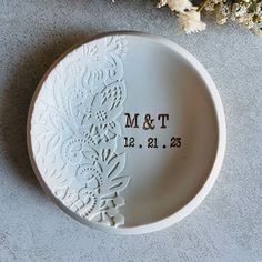 a personalized plate with the date and wedding date on it next to some flowers