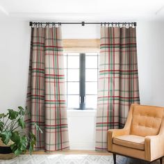 a living room with a chair, window and potted plant in front of it