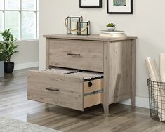 a wooden dresser with two drawers and pictures on the wall