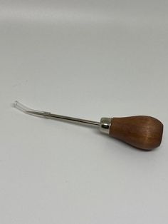 a wooden handle with metal tips on a white surface