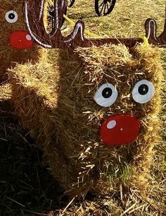 two fake reindeer heads sitting on top of hay