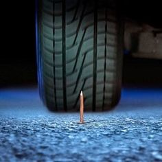 a small orange cone sitting in the middle of a blue floor next to a tire