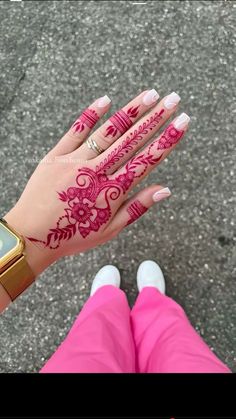 a woman's hand with henna tattoos on it