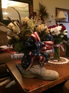 a pair of white shoes sitting on top of a wooden table next to a vase filled with flowers