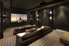 a home theater with two couches and a projector screen in the middle of the room