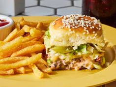 a sandwich and french fries on a yellow plate