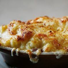 a casserole dish with cheese on top in a brown bowl, ready to be eaten