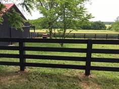 a black fence in front of a barn