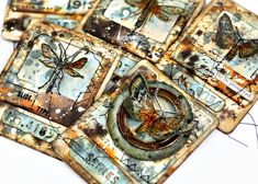 four square coasters with dragonflies and butterflies on them, all made out of scrapbook pages