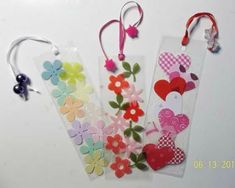 three tags with flowers and hearts on them are hanging next to each other in the shape of butterflies