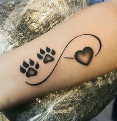 a dog paw and heart tattoo on the arm