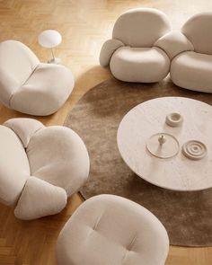 a living room filled with white furniture on top of a hard wood floor