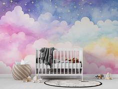 a baby crib in front of a wall with clouds and stars painted on it