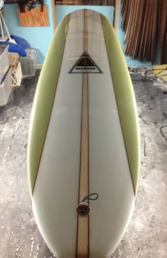 a surfboard sitting on top of a table in a room filled with other items