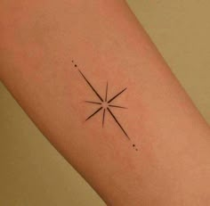 a small star tattoo on the right arm and leg, with dots around it in black ink