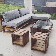 a couch and table made out of wooden pallets on a patio with grass in the background