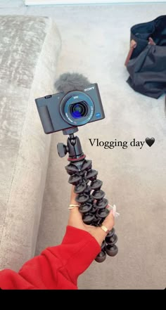 a person is holding a camera on a tripod