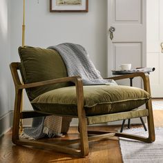 a chair with a blanket on it sitting in front of a door and coffee table