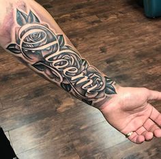 a man's arm with roses on it and the word love written in cursive writing