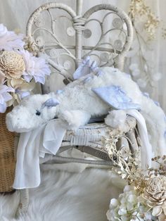 a stuffed animal sitting on top of a white chair next to flowers and a basket