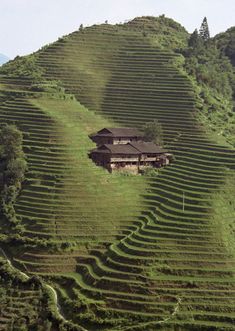 a house on the side of a hill covered in grass