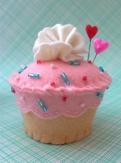 a cupcake with pink icing and sprinkles on top is shown