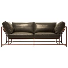 a black leather couch with metal frame legs