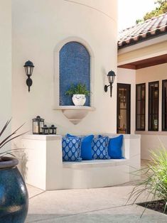 a blue and white couch sitting on top of a patio next to a potted plant