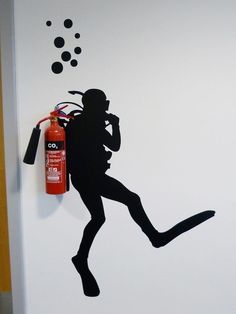 a fire extinguisher is silhouetted against a wall with an oxygen tube