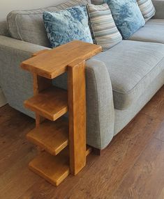 a living room with a gray couch and wooden stairs