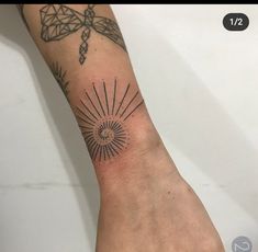 a person's arm with a tattoo on it and the sun in the middle