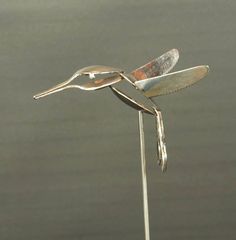 a metal bird sculpture sitting on top of a table